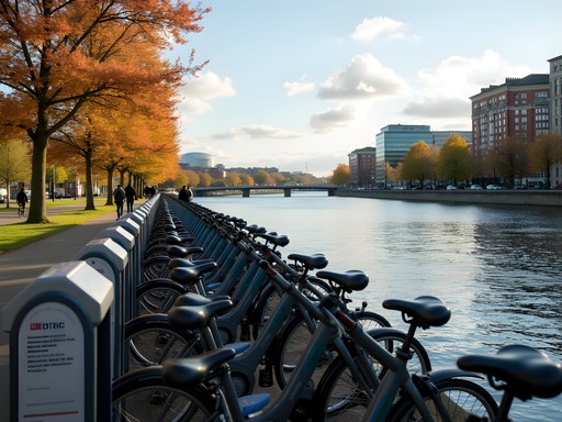 Belfast Bikes sharing station near river with autumn foliage and city skyline