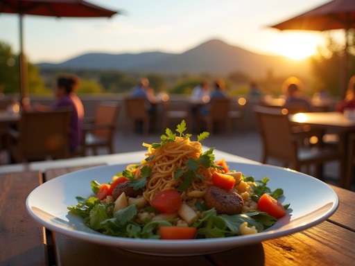 Colorful vegan meal on outdoor restaurant patio with Sandia Mountains visible in background during sunset