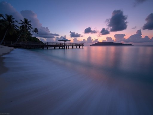 Long exposure seascape of Coconut Bay Beach at twilight with silky water effect and pier silhouette
