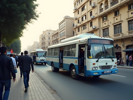 Crowded Cairo street corner with white and blue microbuses picking up passengers